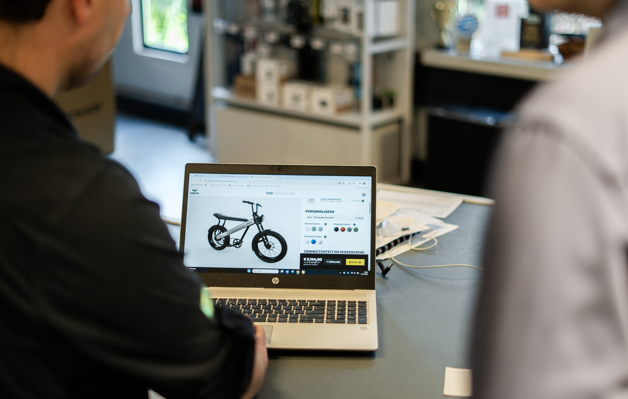 Een medewerker van Pedaleur helpt een klant een Brekr fiets samenstellen